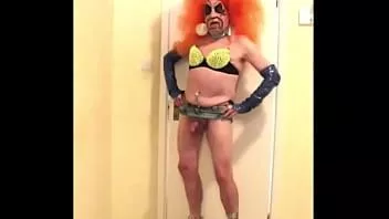 Riproduci Troia dai capelli arancioni in reggiseno verde borchiato e zeppe fetish